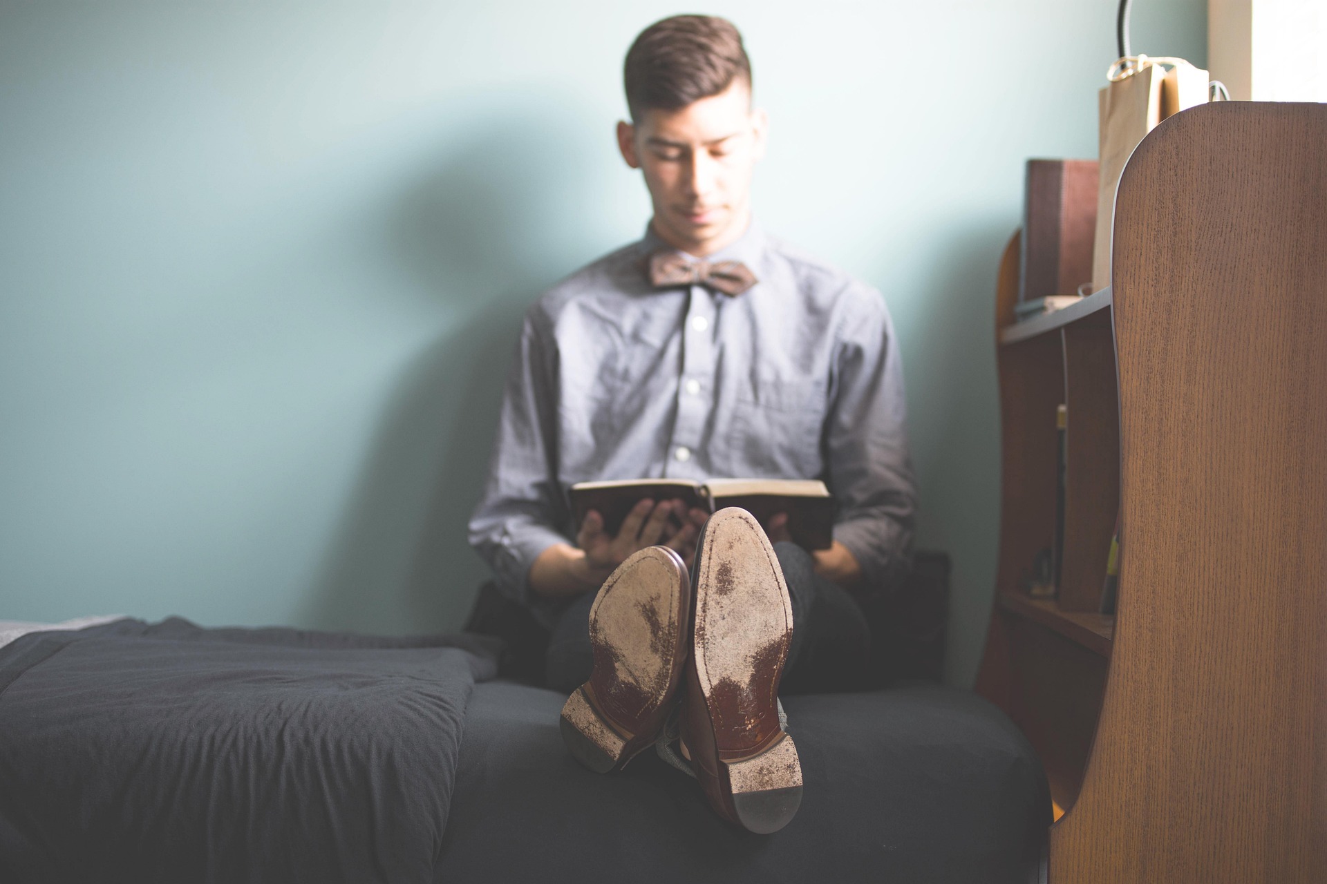 A student sitting quietly in a room reading a book at his own pace